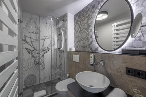 a bathroom with a toilet and a sink and a mirror at Hotel Schäfflerwirt in Aschheim