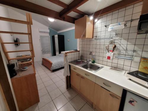 a kitchen with a sink and a bed in a room at "Le studio" in Mouilleron-le-Captif