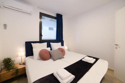 a bedroom with a large white bed with two pillows at YalaRent Migdalor Apartments with Sea Views Tiberias in Tiberias