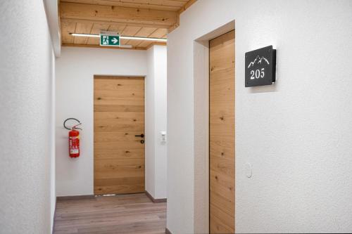 a hallway with a door and a sign on a wall at AlpinSpa zur Post - Bergbahn im Sommer 2025 inklusive in Bad Gastein
