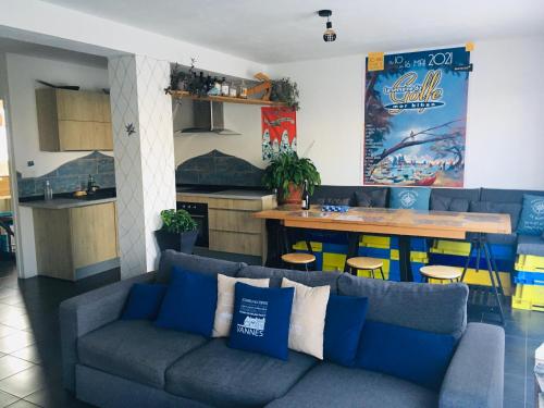 a living room with a couch and a kitchen at Maison LE BONO KERBISOUNOURS in Le Bono