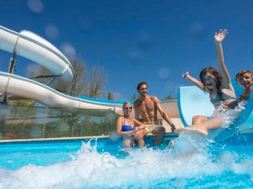 a group of people sitting on a water slide at Camping Officiel Siblu Les Rives de Condrieu in Condrieu