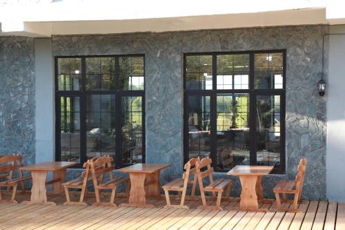 a group of tables and chairs in front of a building at Olive Ala-Archa Hotel & SPA in Verkhnyaya Alaarcha