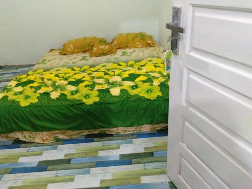 een slaapkamer met twee bedden met gele bloemen erop bij Zahra Syariah Home Stay in Bukittinggi