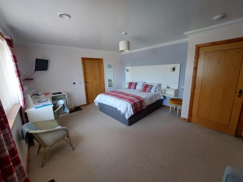 um quarto com uma cama, uma mesa e uma cadeira em Scorrybreac B&B em Broadford