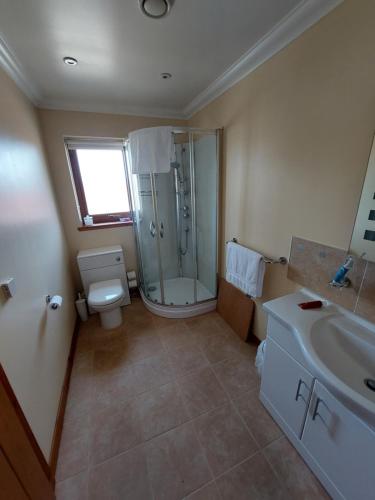 a bathroom with a shower and a toilet and a sink at Scorrybreac B&B in Broadford