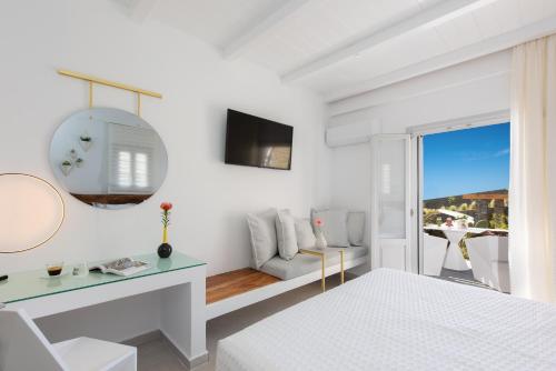 Habitación blanca con cama y espejo en Elements Sifnos Boutique, en Faros
