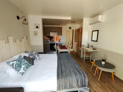 1 Schlafzimmer mit einem großen weißen Bett und einer Küche in der Unterkunft Logis Le Nid du Pont de Gau in Saintes-Maries-de-la-Mer