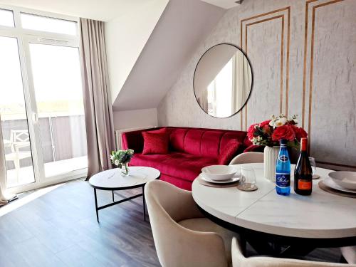 - un salon avec un canapé rouge et une table dans l'établissement Apartament Węgorzewo, à Węgorzewo