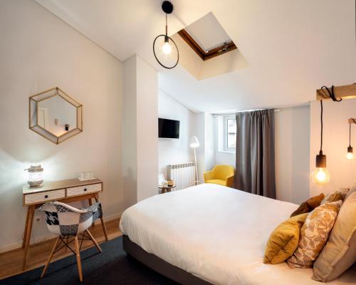 um quarto com uma cama, uma secretária e um espelho em NJOY Coimbra em Coimbra
