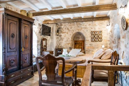 a bedroom with a bed and a table in a room at Dandy Villas Mani - Old Tower House - Fireplace - Pool in Nómia