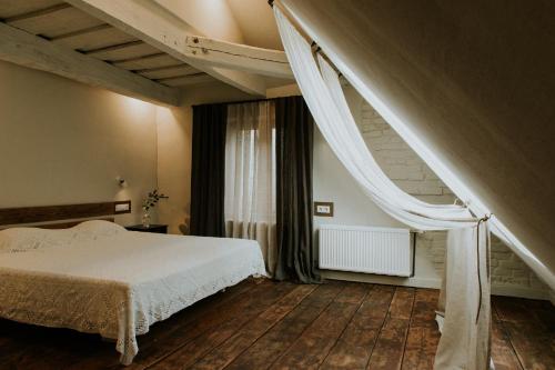 a bedroom with a white bed and a staircase at Kalēju ielas rezidence: Talsu vecpilsētas pērle in Talsi