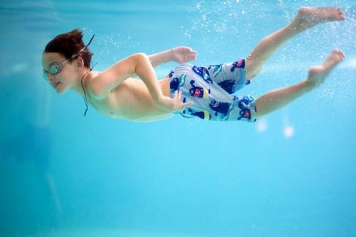 a young girl is swimming in the water at The Resort Studio - New Cairo in Cairo
