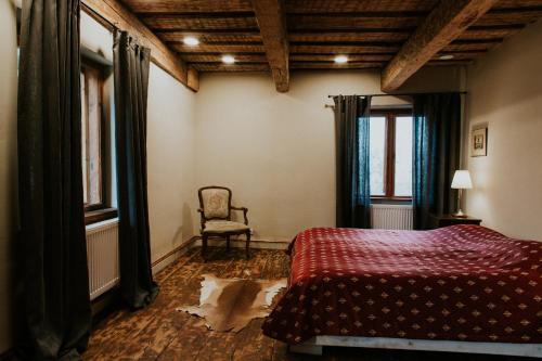 a bedroom with a bed and a chair in it at Kalēju ielas rezidence: Talsu vecpilsētas pērle in Talsi