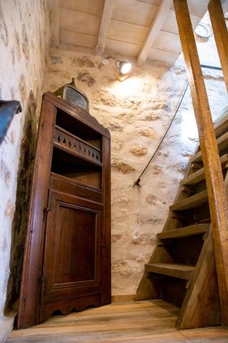 an attic room with a wooden door and stairs at Dandy Villas Mani - Old Tower House - Fireplace - Pool in Nómia