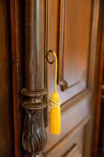 a yellow tassel hanging from a door with a window at Dandy Villas Mani - Old Tower House - Fireplace - Pool in Nómia