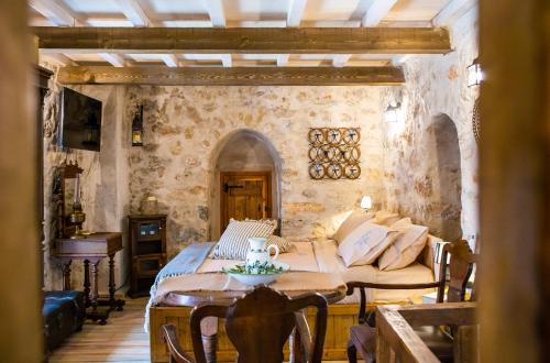 a bedroom with a bed and a table in a room at Dandy Villas Mani - Old Tower House - Fireplace - Pool in Nómia