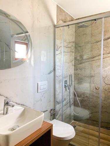 a bathroom with a shower and a sink and a toilet at Hotel Meta Ksamil in Ksamil