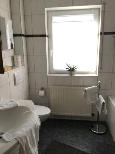 a bathroom with a white toilet and a window at Ferienwohnung Loretta in Traben-Trarbach