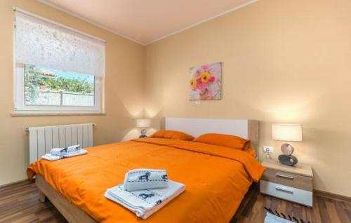 una camera da letto con un grande letto arancione e una finestra di Apartment Liam a Novigrad Istria