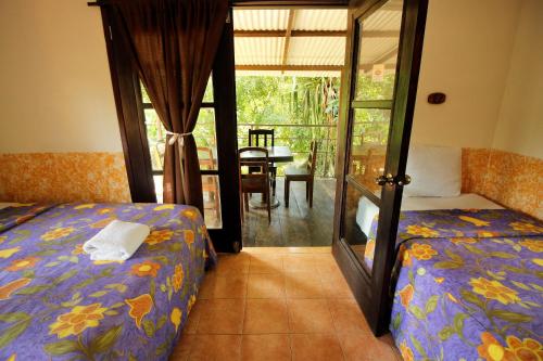 a bedroom with a bed and a glass door to a patio at Cabañas Kin Balam Palenque in Palenque