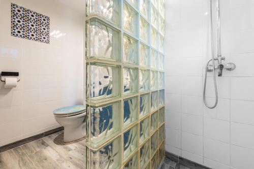 a bathroom with a toilet and a glass wall at Finca Las Nuevas Casa Sofia in Alora