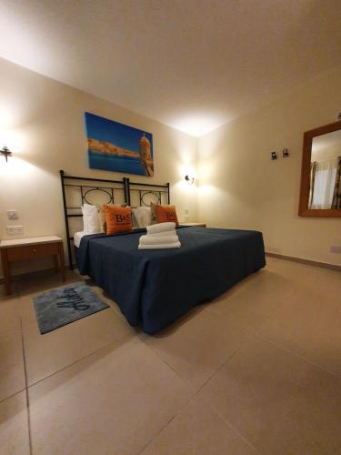 una camera da letto con letto con lenzuola blu e cuscini arancioni di B&S Accommodation Penthouse 602 a Hal Ghaxiak