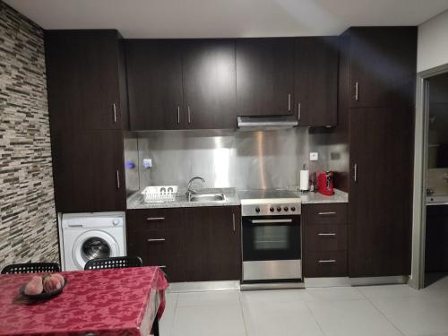a kitchen with brown cabinets and a sink and a stove at Maison de vacances et week-end, 2 in Esposende
