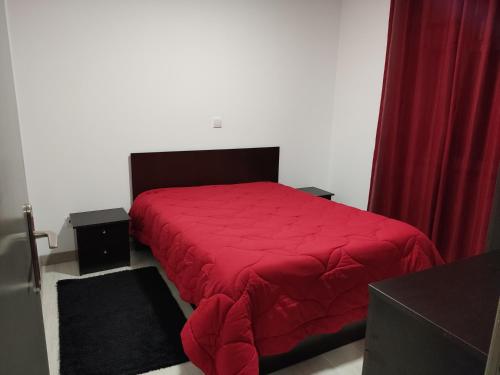 1 dormitorio con cama roja y cortinas rojas en Maison de vacances et week-end, 2 en Esposende