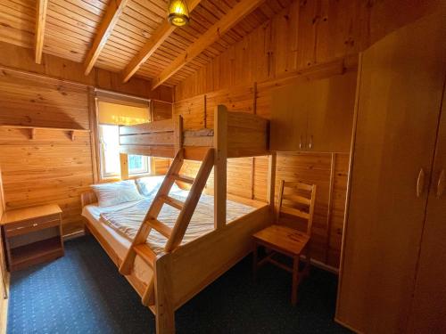 a bedroom with a bunk bed in a wooden cabin at Domki Rodzinny Wypoczynek in Mikołajki