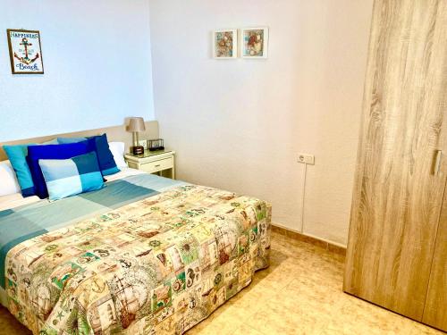 a bedroom with a bed with blue walls and blue pillows at Casa Marinera en Palamós in Palamós