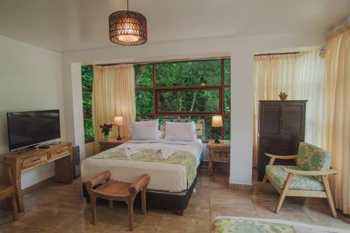 um quarto com uma cama e uma grande janela em Rupa Rupa High Jungle Eco B&B em Machu Picchu