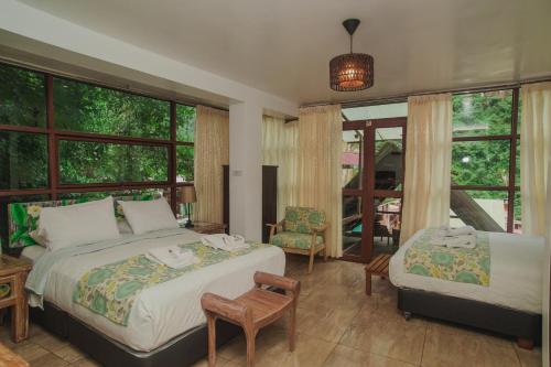 a bedroom with two beds in a room with windows at Rupa Rupa High Jungle Eco B&B in Machu Picchu