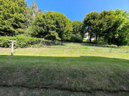 a field of grass with a fence and trees at Les Petites Fécampoises by Mathilde in Fécamp