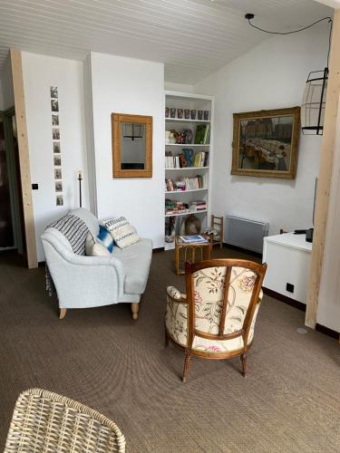 sala de estar con sofá y silla en La Terrasse du Bois Plage, en Le Bois-Plage-en-Ré