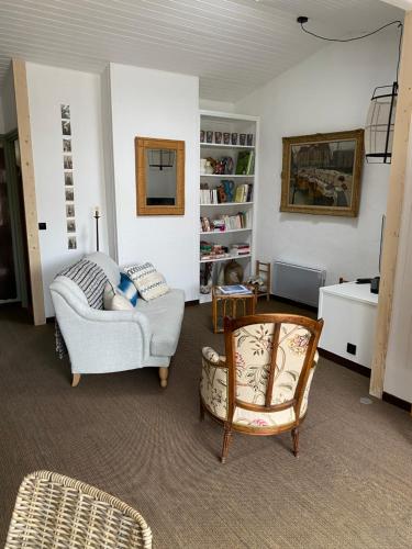 a living room with a couch and a chair at La Terrasse du Bois Plage in Le Bois-Plage-en-Ré