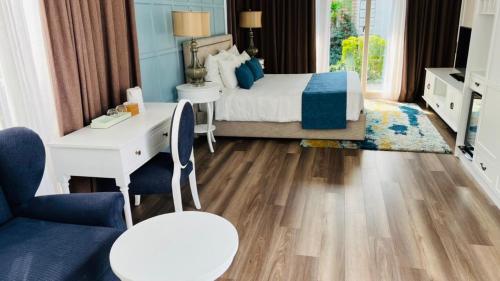 a bedroom with a bed and a desk and a chair at Villas at Oceanami Resort in Long Hai