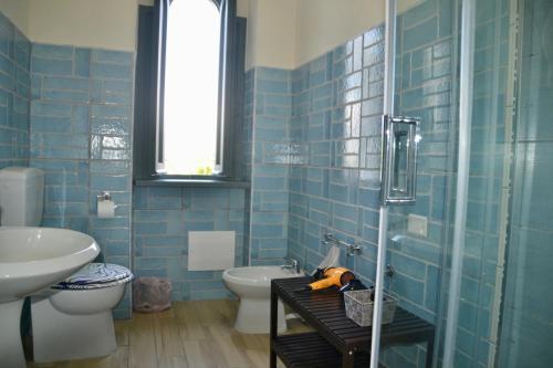 a blue tiled bathroom with a toilet and a sink at Sperlonga Paradise Suites 500m dal mare in estate Servizio navetta per Sperlonga centro in Sperlonga