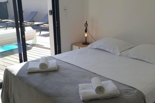 une chambre avec un lit avec des serviettes dessus dans l'établissement Villa Rossa 6 pers dans résidence avec piscine chauffée privée, à Lecci