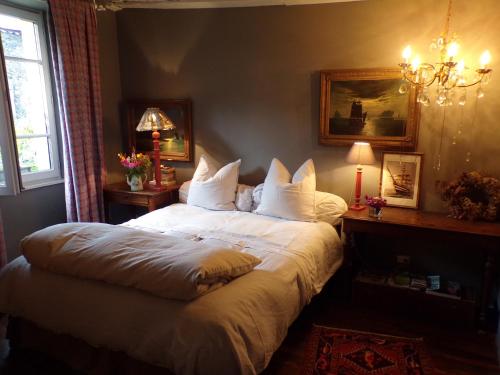 a bedroom with a large bed with white sheets and pillows at la maison de Royer in Meuzac