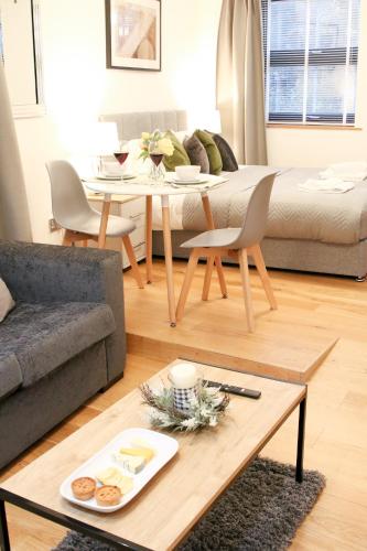 a living room with a table and a couch at Lovely Studio Apartment with access for Wheel-chairs in Sydenham in Forest Hill