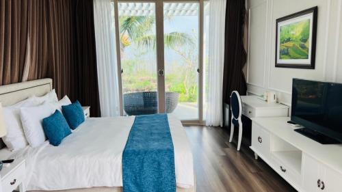a bedroom with a bed and a tv and a window at Villas at Oceanami Resort in Long Hai