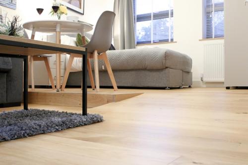 a living room with a table and a couch at Lovely Studio Apartment with access for Wheel-chairs in Sydenham in Forest Hill