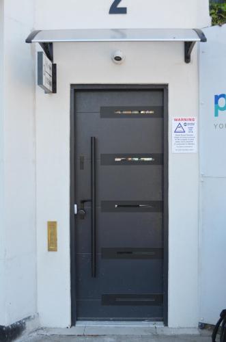 a black door on the side of a building at Lovely Studio Apartment with access for Wheel-chairs in Sydenham in Forest Hill