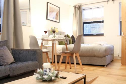 uma sala de estar com uma mesa e um sofá em Lovely Studio Apartment with access for Wheel-chairs in Sydenham em Forest Hill