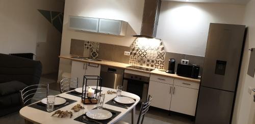 une cuisine avec une table et des chaises dans une pièce dans l'établissement Gîte du Domaine de Lussier, à Générac