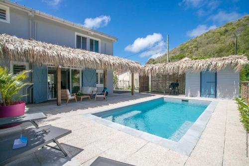 a villa with a swimming pool and a house at Villa Sunrays in Sainte-Anne