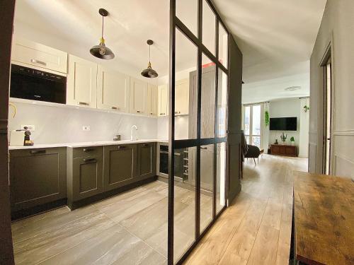 une cuisine avec des armoires blanches et un plancher en bois dans l'établissement Bioves en Duplex-climatisation-centre ville-plage, à Menton