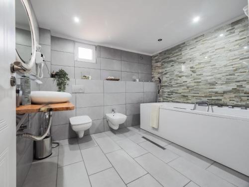 a bathroom with a tub and a toilet and a sink at For You Apartments Gold & Silver in Sibiu