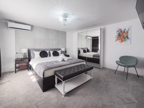 ein Schlafzimmer mit einem Bett, einem Stuhl und einem Spiegel in der Unterkunft For You Apartments Gold & Silver in Sibiu